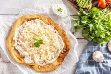 hungarian traditional langos with garlic, cream, and cheese